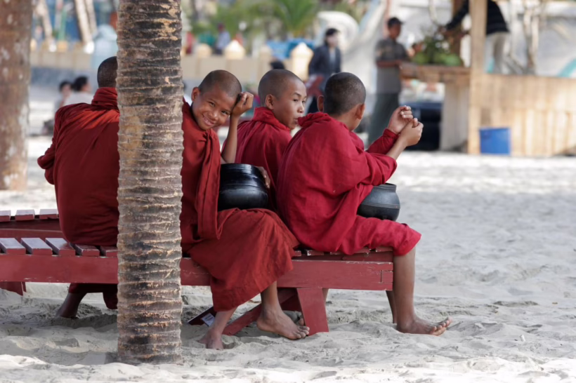 young monks waiting for alms at chaung tha beach