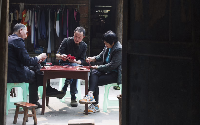 Villagers in Bagou playing cards to kill time