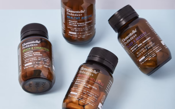Four bottles of Elementelle Probiotics+ arranged artfully against a light blue background