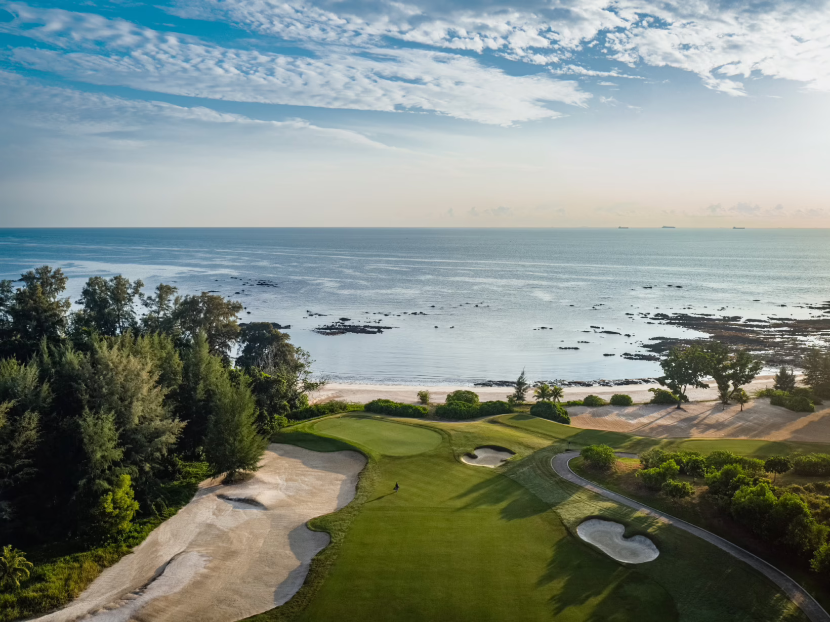 Golf course overlooking lush greenery and coastal waters at The Els Club Desaru Coast