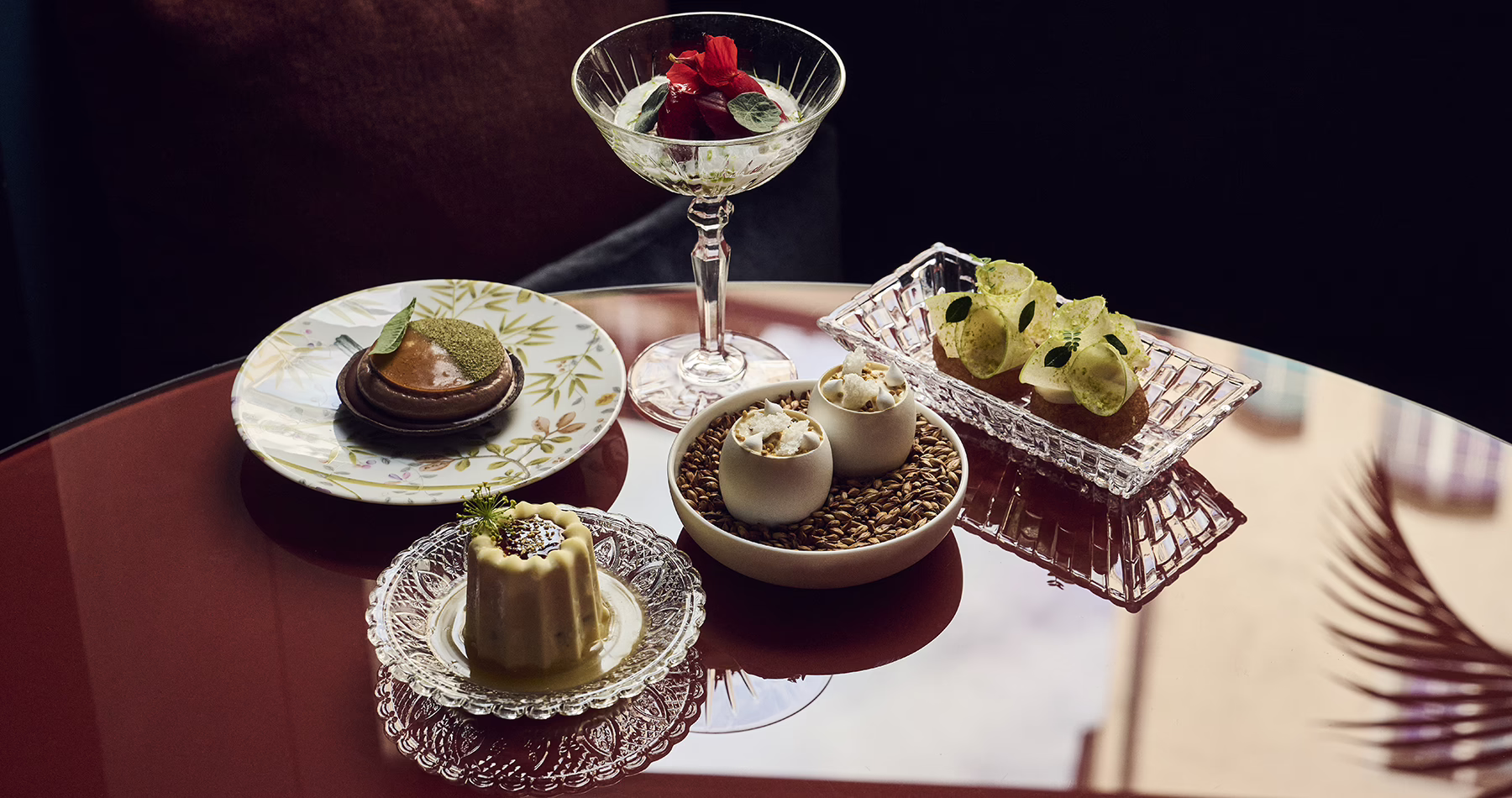 Selection of sharing dishes and a cocktail at IGNIV Zurich by chef Andreas Caminada.