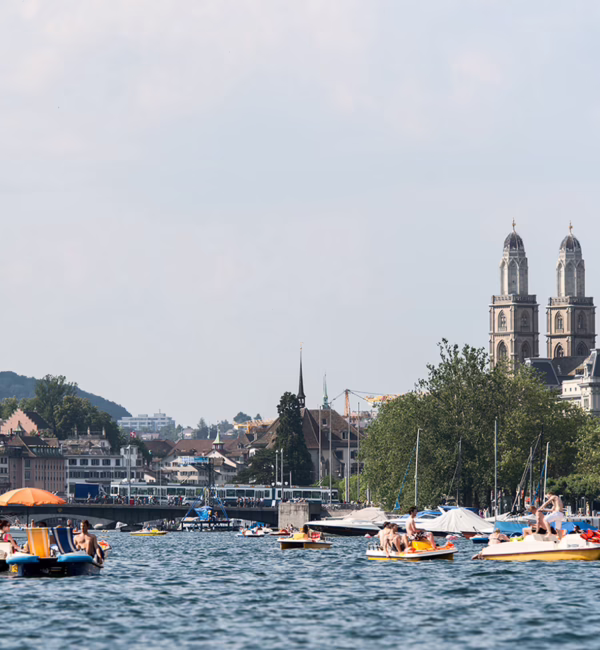 Passengers taking in views of Lake Zurich and the surrounding landscape from a cruise boat.