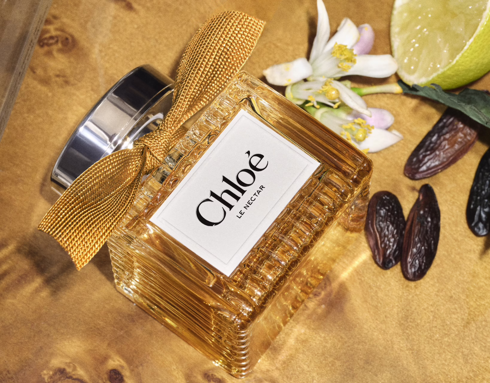 Chloé Le Nectar Parfum Intense bottle with its golden-beige ribbon and amber-toned fragrance.