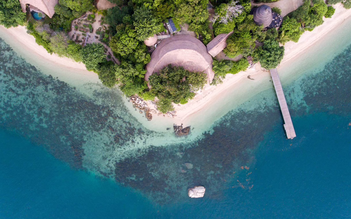 Tropical coastline, clear waters and lush greenery on Cempedak Island, Indonesia.
