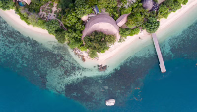 Tropical coastline, clear waters and lush greenery on Cempedak Island, Indonesia.