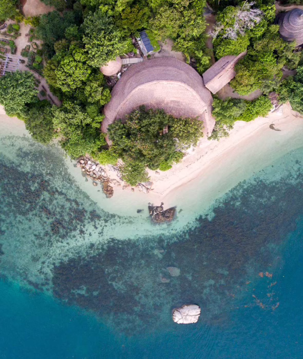 Tropical coastline, clear waters and lush greenery on Cempedak Island, Indonesia.