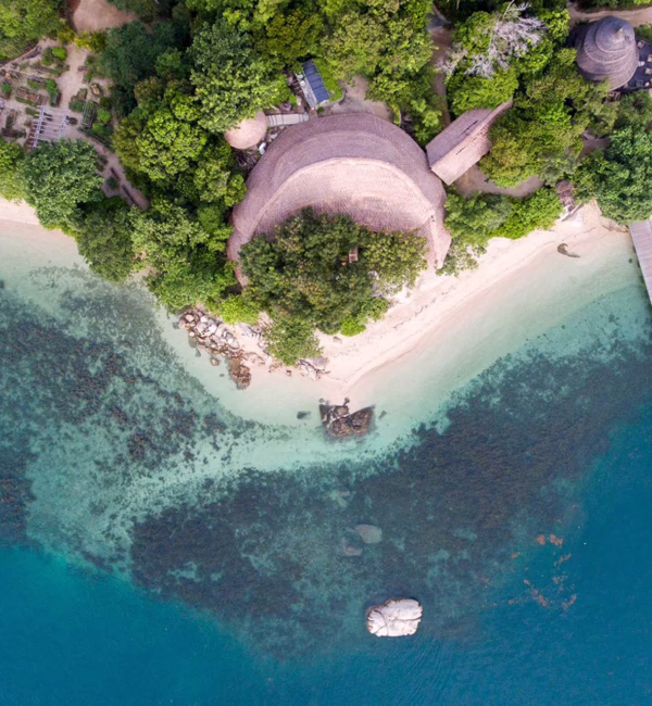 Tropical coastline, clear waters and lush greenery on Cempedak Island, Indonesia.
