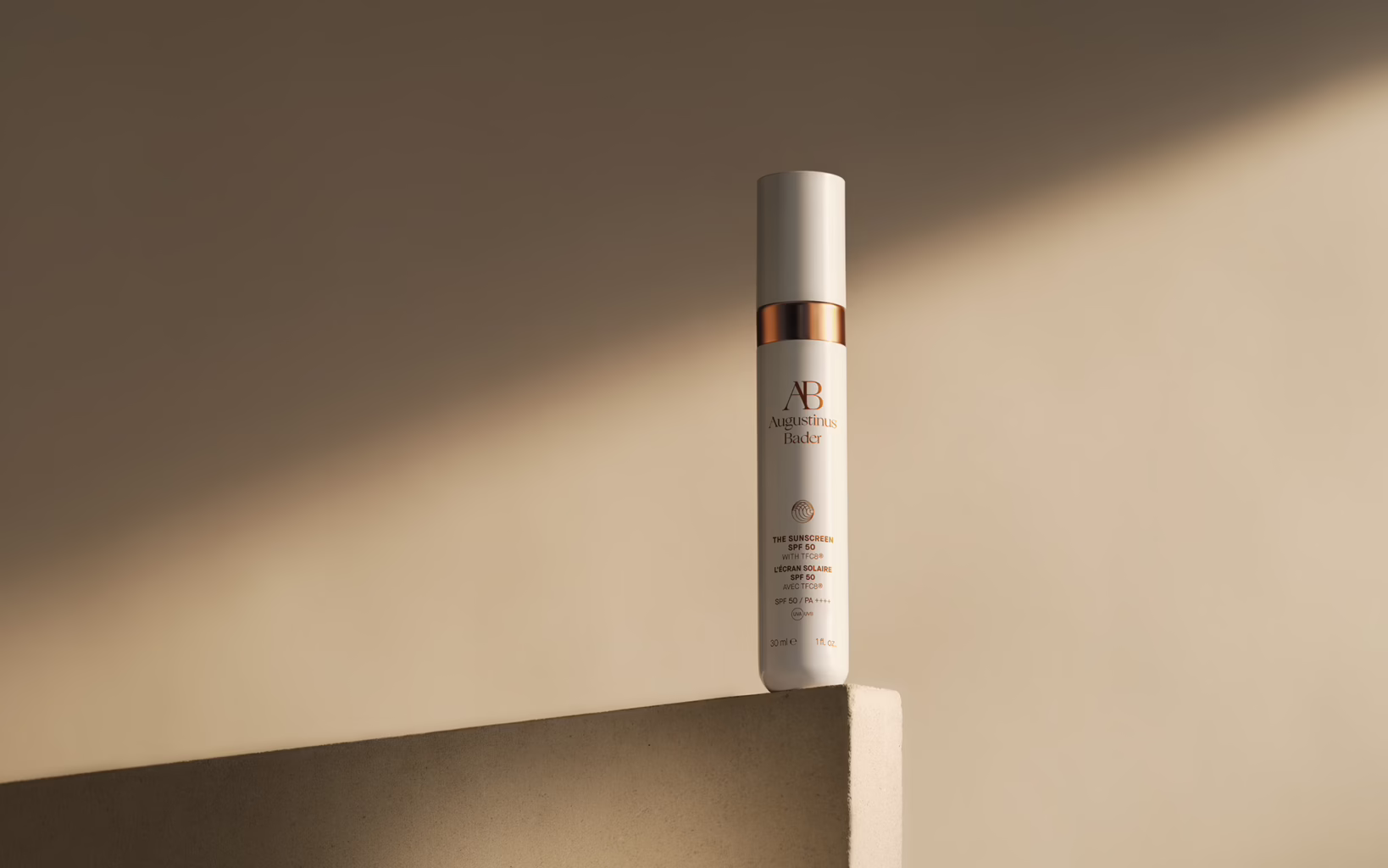 Augustinus Bader The Sunscreen SPF 50 in a white bottle with copper accents
