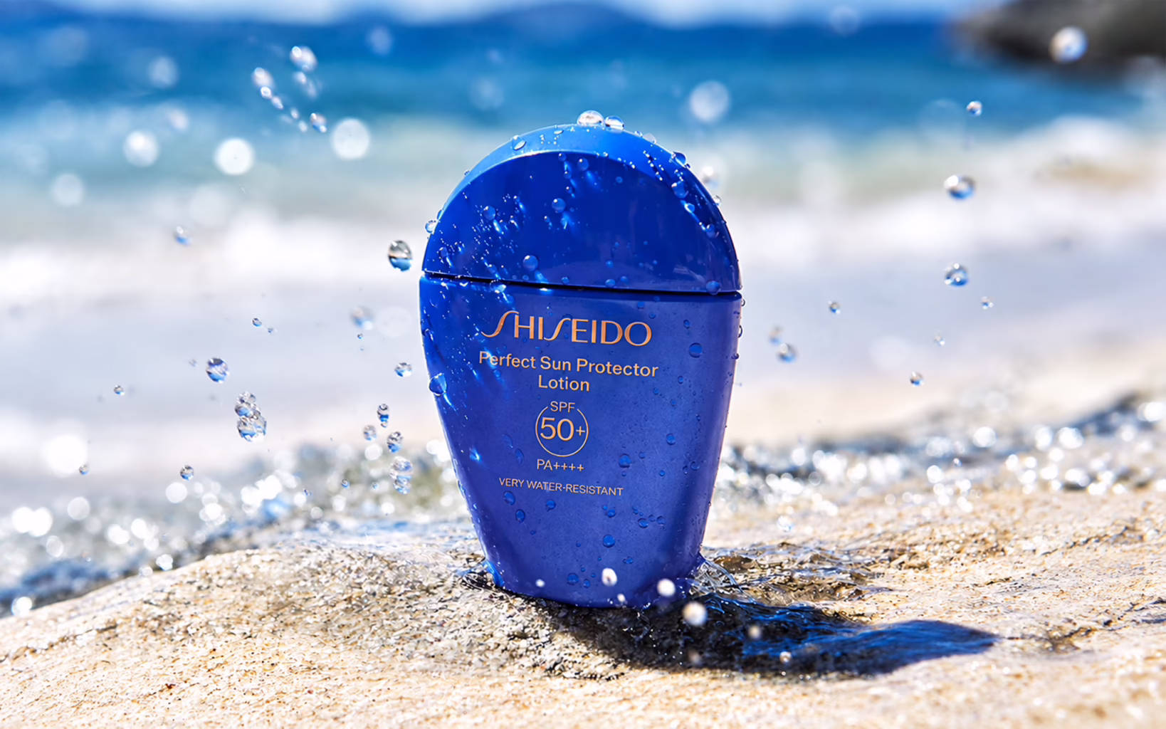 Shiseido Perfect Sun Protector Lotion SPF50+ PA++++ with water droplets by the sea