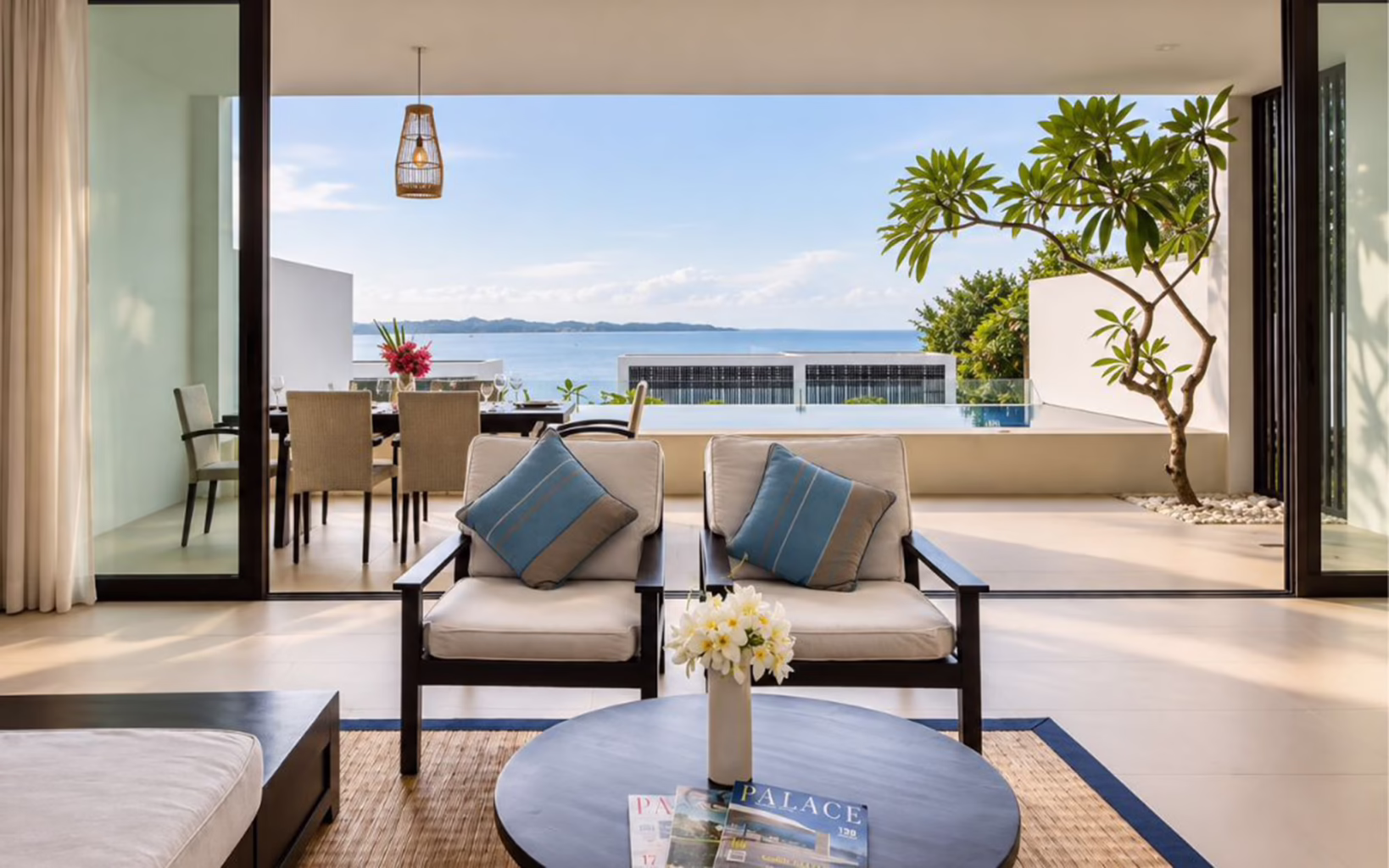 Spacious villa living area at Montigo Resorts Nongsa in Batam, opening onto a private infinity pool and terrace overlooking the Singapore Strait.