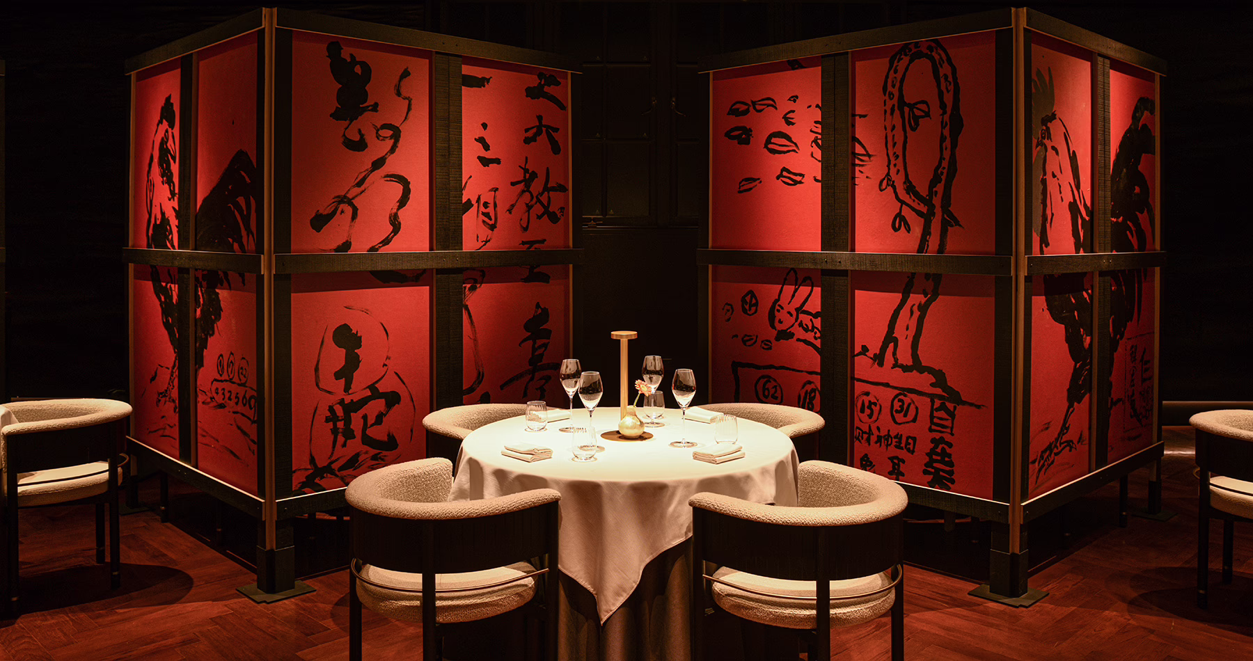 Dining room at Ling Long Shanghai, featuring rich red tones and contemporary artworks inspired by Chinese calligraphy.