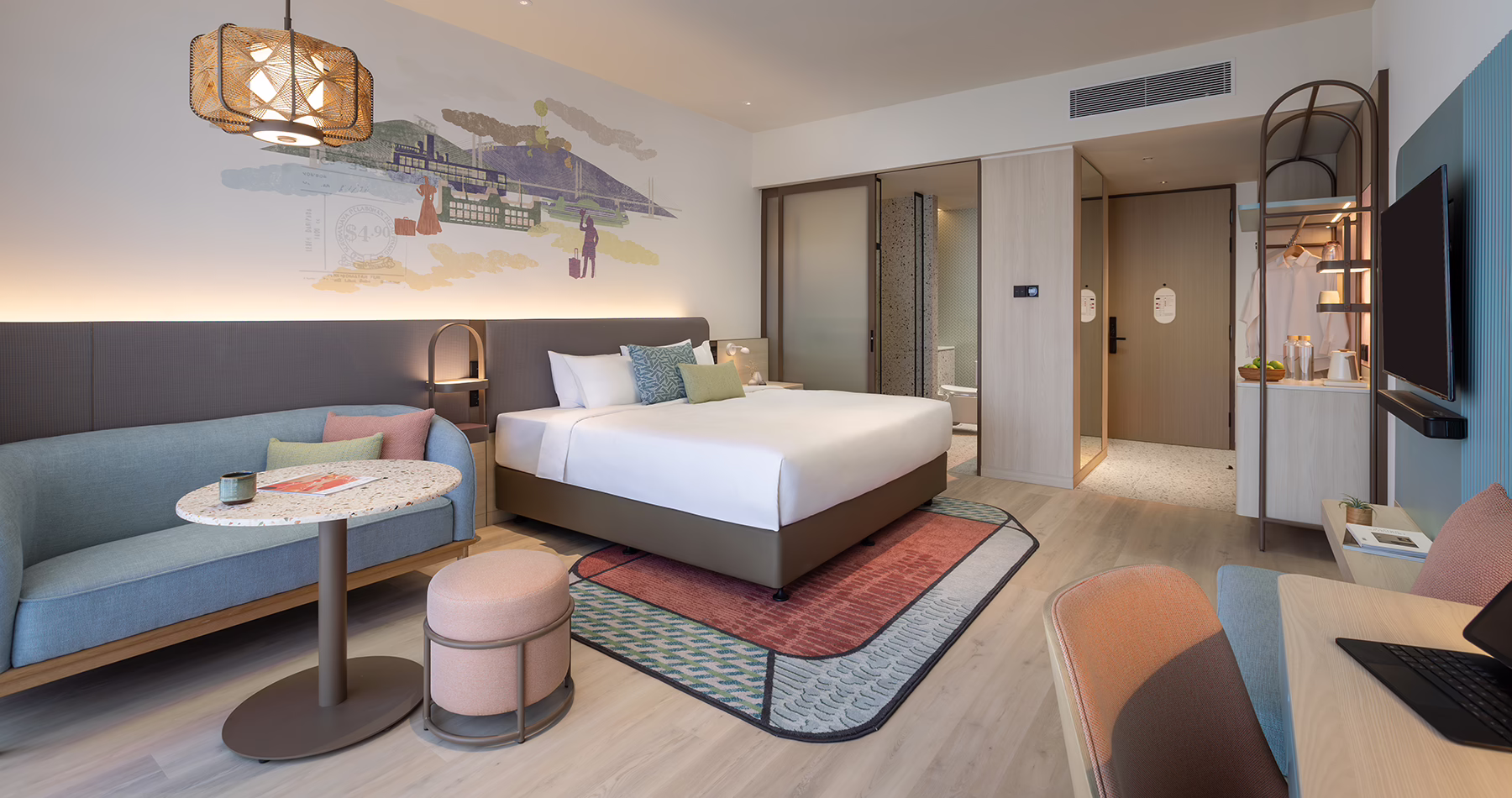 Premier King room at Capri by Fraser, Penang, featuring a king-sized bed, sofa, work desk and colourful interiors inspired by Penang's cultural heritage.
