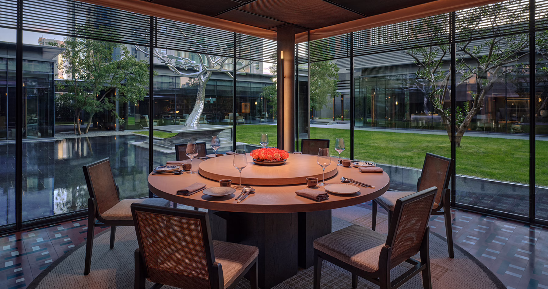 Set dining table at 500 Wei Hai Road in Alila Shanghai, framed by floor-to-ceiling glass panels overlooking the outdoors