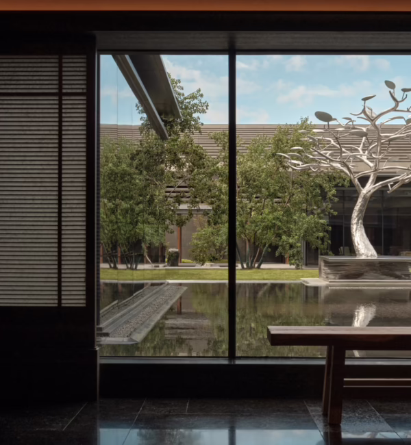 Ground floor of Alila Shanghai looking towards the outdoor water feature and artwork framed by the hotel’s contemporary design.