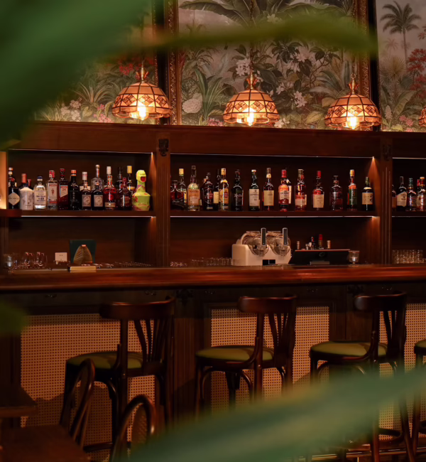The intimate interior of Alma Luna in Shanghai, featuring emerald leather, warm wood and brass accents inspired by Havana.