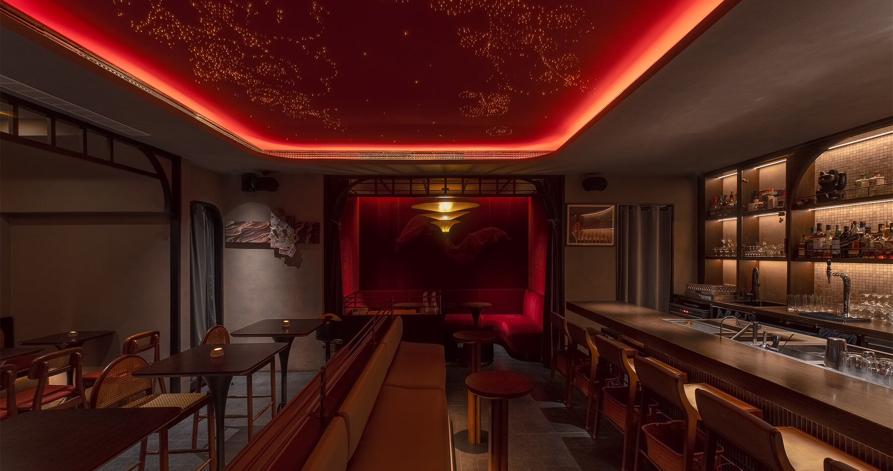 Interior of Asian Flush Shanghai, featuring warm lighting, dark wood and red accents.