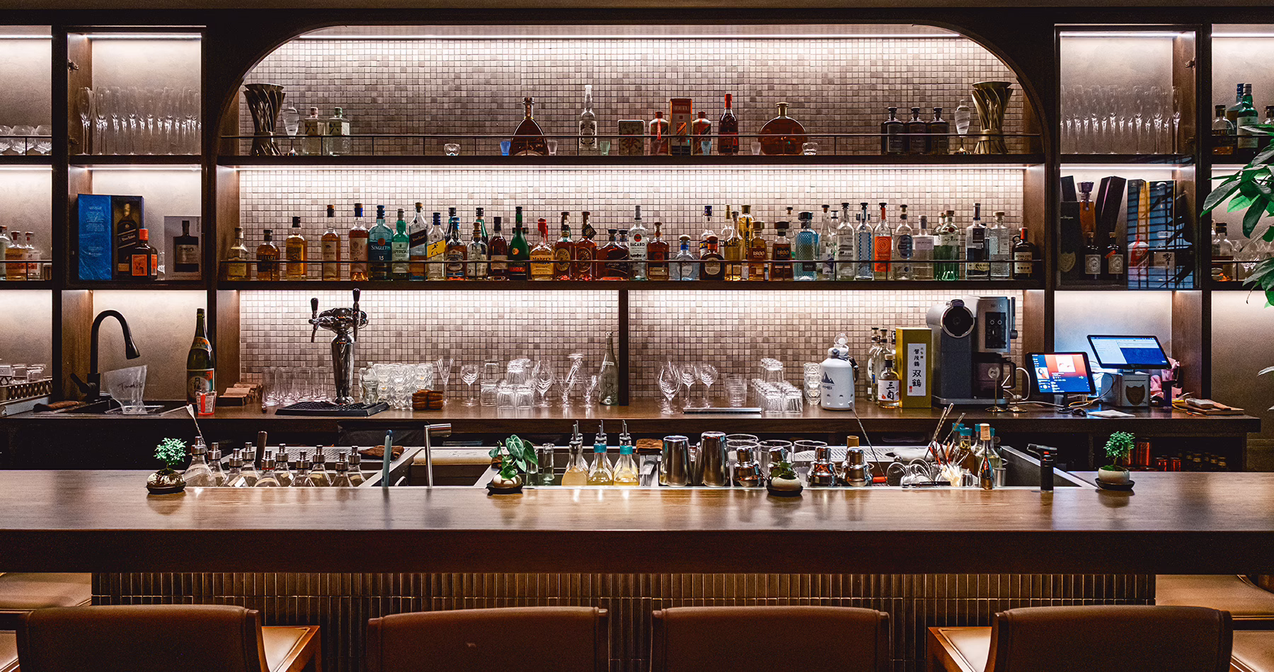 Back bar at Asian Flush Shanghai, lined with spirits and illuminated shelving.