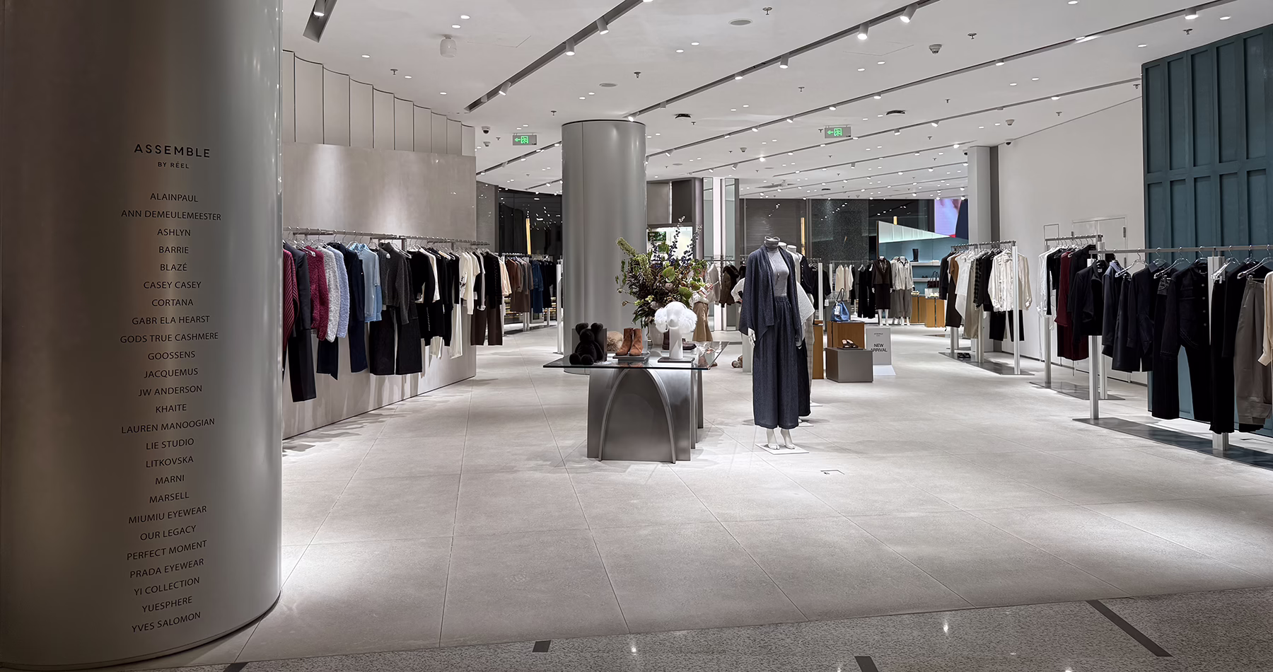 Interior of ASSEMBLE by Réel at Reel Shanghai, featuring designer clothing racks, mannequins and minimalist displays.