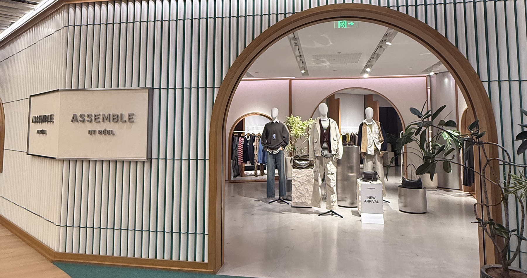 Arched entrance to ASSEMBLE by Réel at Reel Shanghai, with mannequins displaying contemporary clothing and accessories.