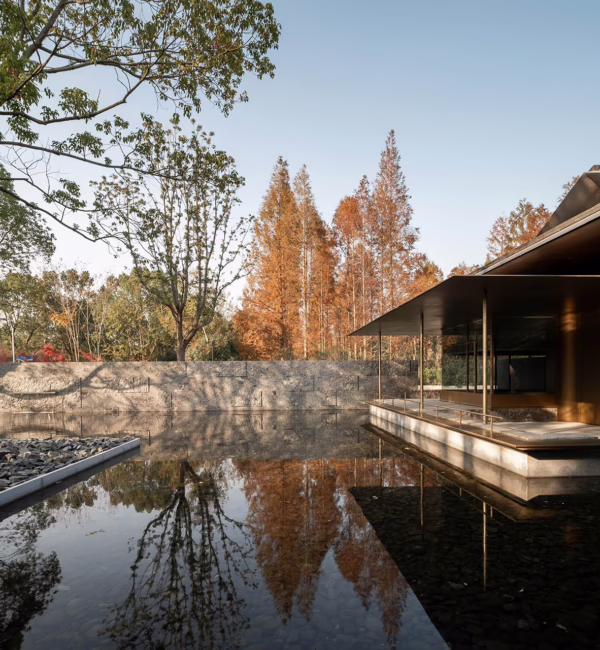 Reflective courtyard and water garden at Shanghai Muh Shoou Zhujing, surrounded by trees and contemporary Jiangnan-inspired architecture.
