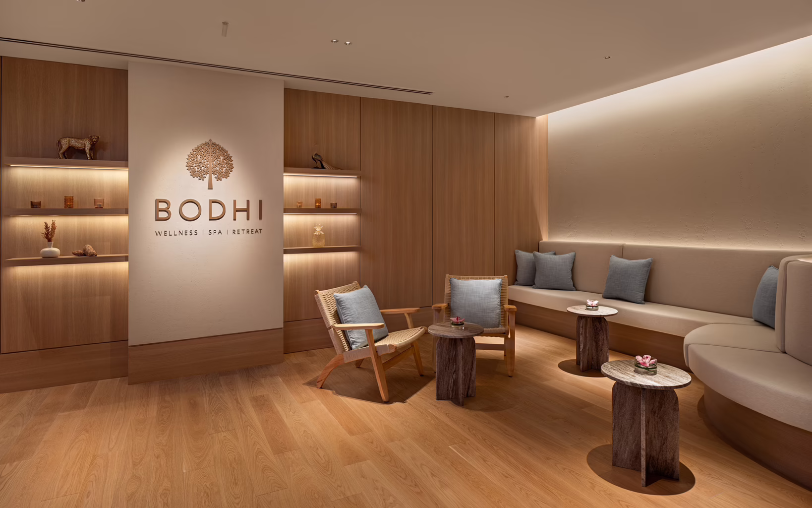 The relaxation lounge at BODHI Spa in The Laurus, Resorts World Sentosa, featuring warm timber interiors, cushioned seating, soft lighting and minimalist décor.